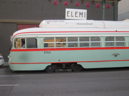 A passing streetcar momentarily blocks the view of Elemi